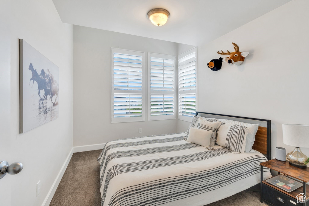 Bedroom featuring carpet and baseboards