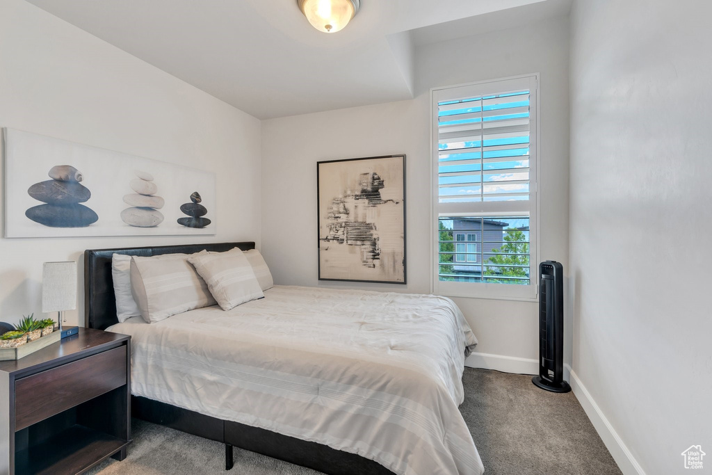 Bedroom featuring baseboards, multiple windows, and carpet flooring