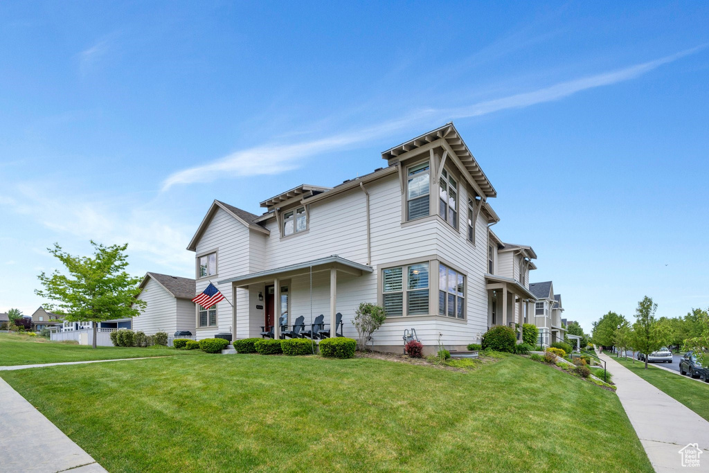View of front facade featuring a front lawn and covered porch