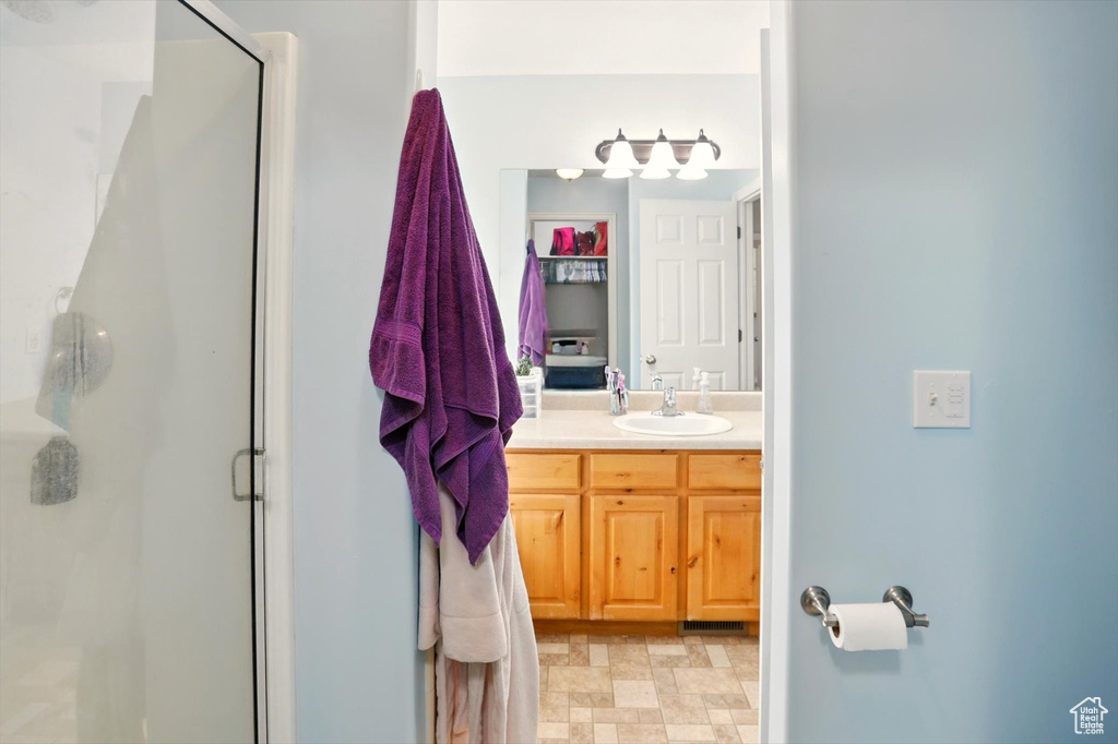 Full bath featuring a stall shower and vanity