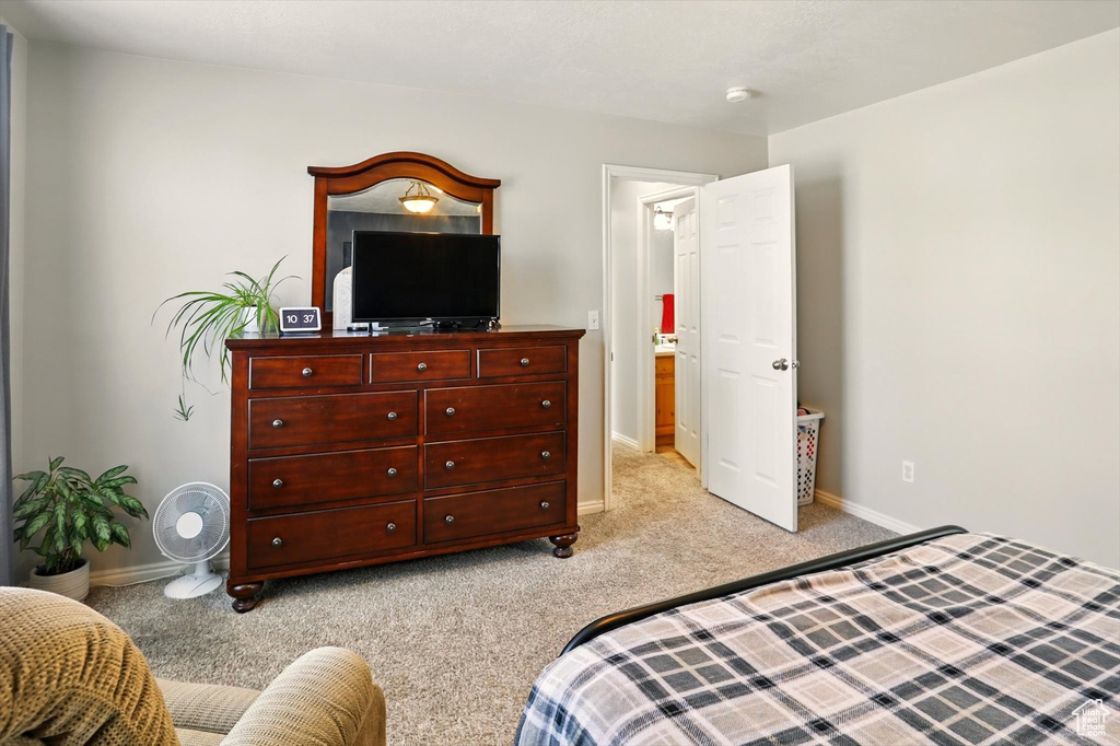 Bedroom featuring light carpet and baseboards