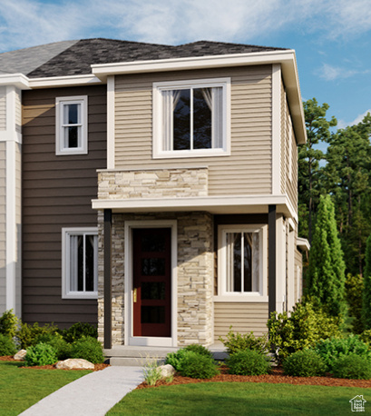 View of front of home featuring stone siding and a front yard
