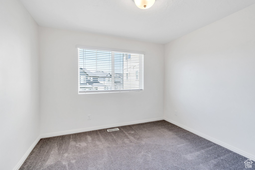 Carpeted empty room featuring baseboards