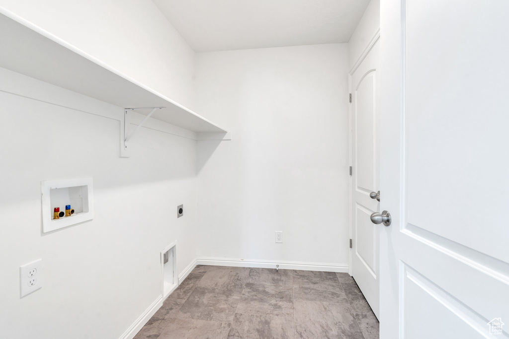 Washroom with hookup for an electric dryer, washer hookup, and baseboards