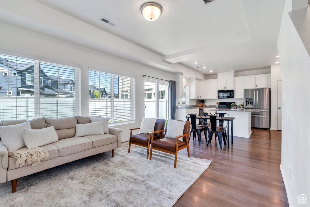 Living room featuring dark wood-style flooring, recessed lighting, and baseboards