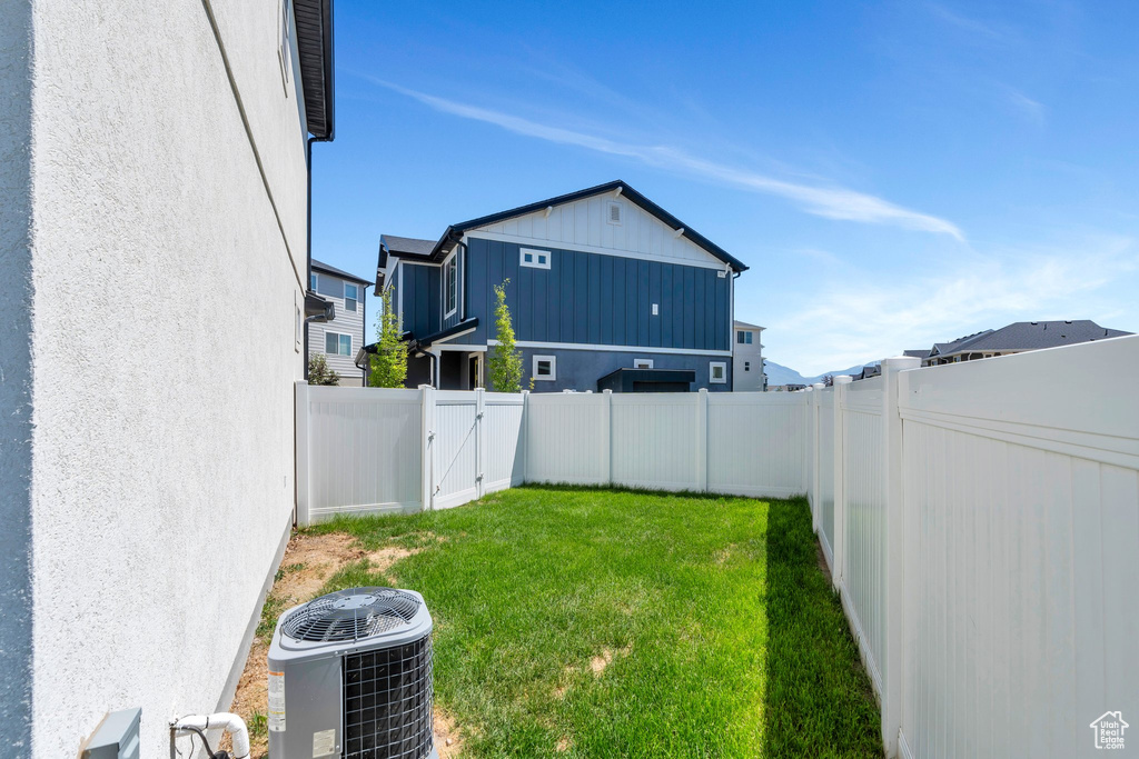 View of yard featuring central air condition unit and a gate