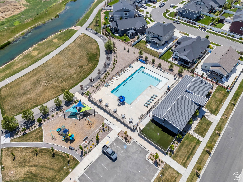 Aerial perspective of suburban area with a nearby body of water and a pool