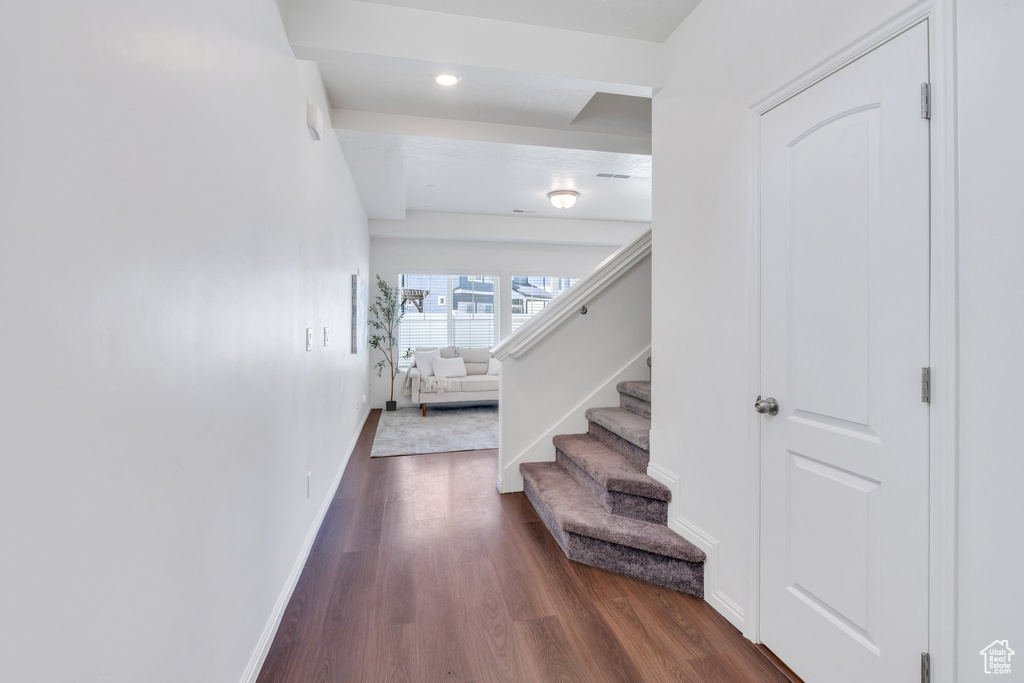 Hall with dark wood-style floors, stairs, baseboards, and recessed lighting