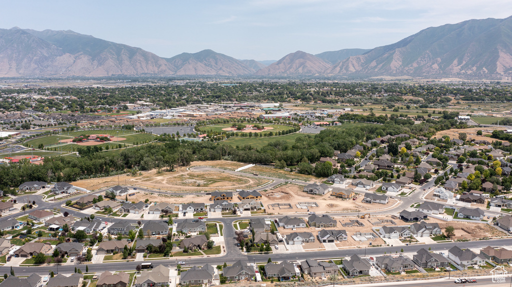 Aerial view of property and surrounding area featuring mountains and nearby suburban area