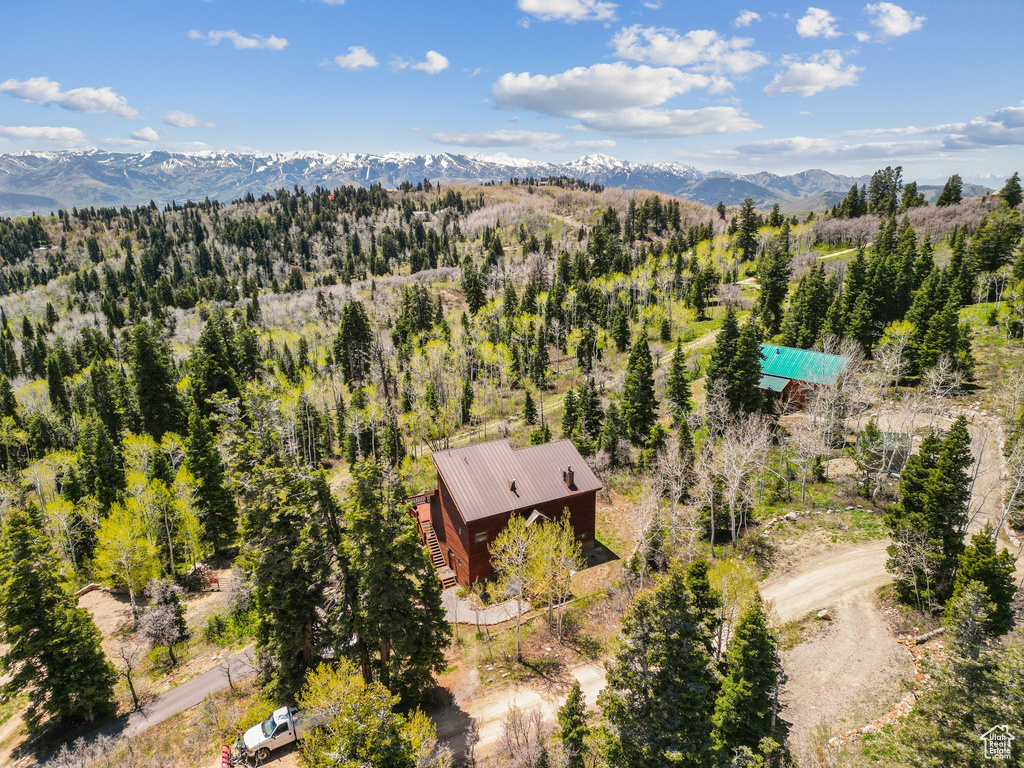 View of subject property featuring mountains and a heavily wooded area