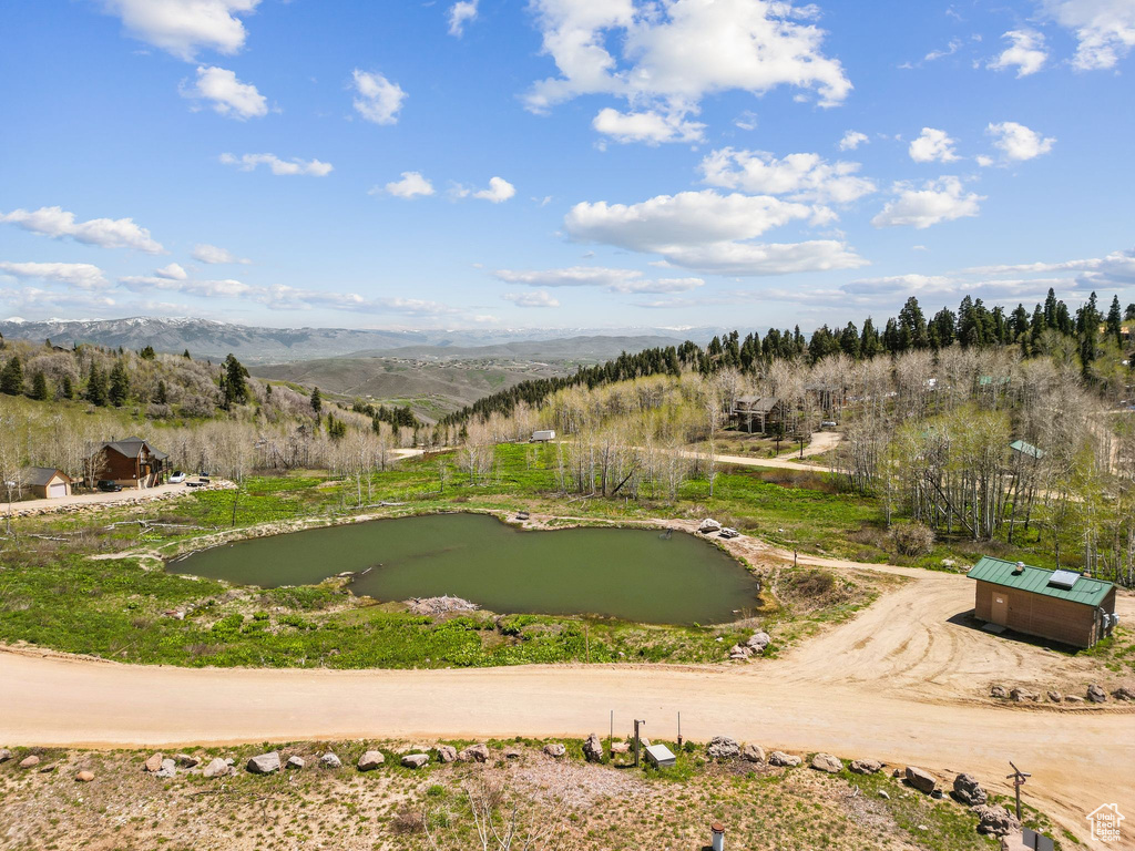 Surrounding community featuring a putting green and a water and mountain view