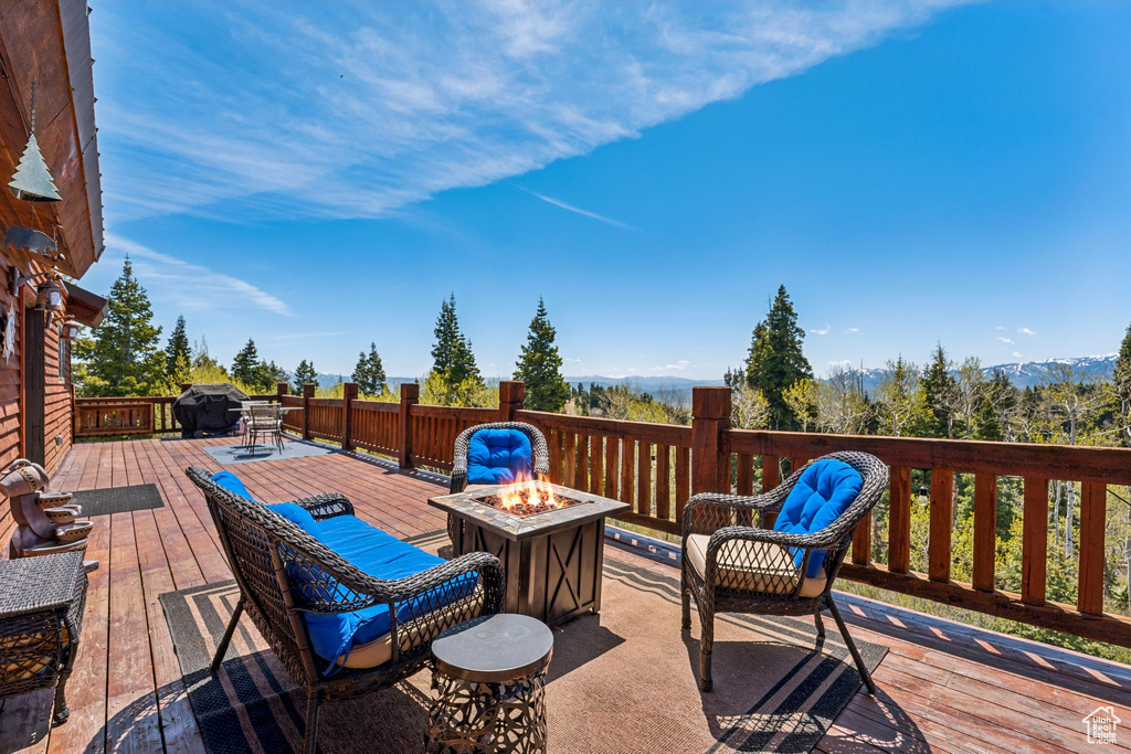 Wooden deck with an outdoor fire pit and grilling area