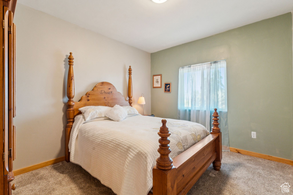 Bedroom featuring light colored carpet and baseboards