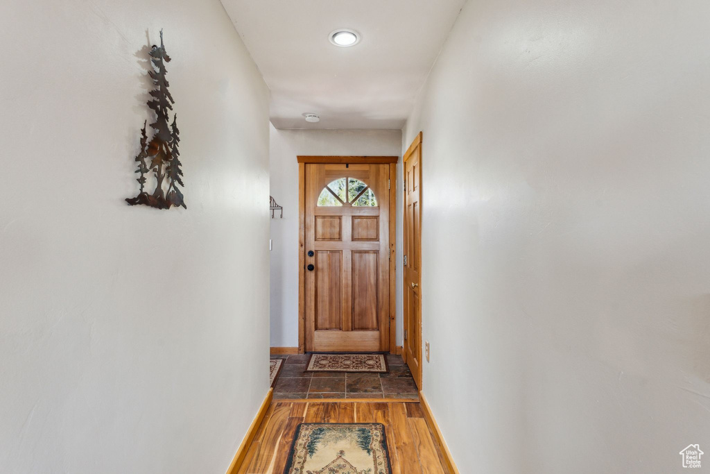 Doorway to outside with wood finished floors and baseboards