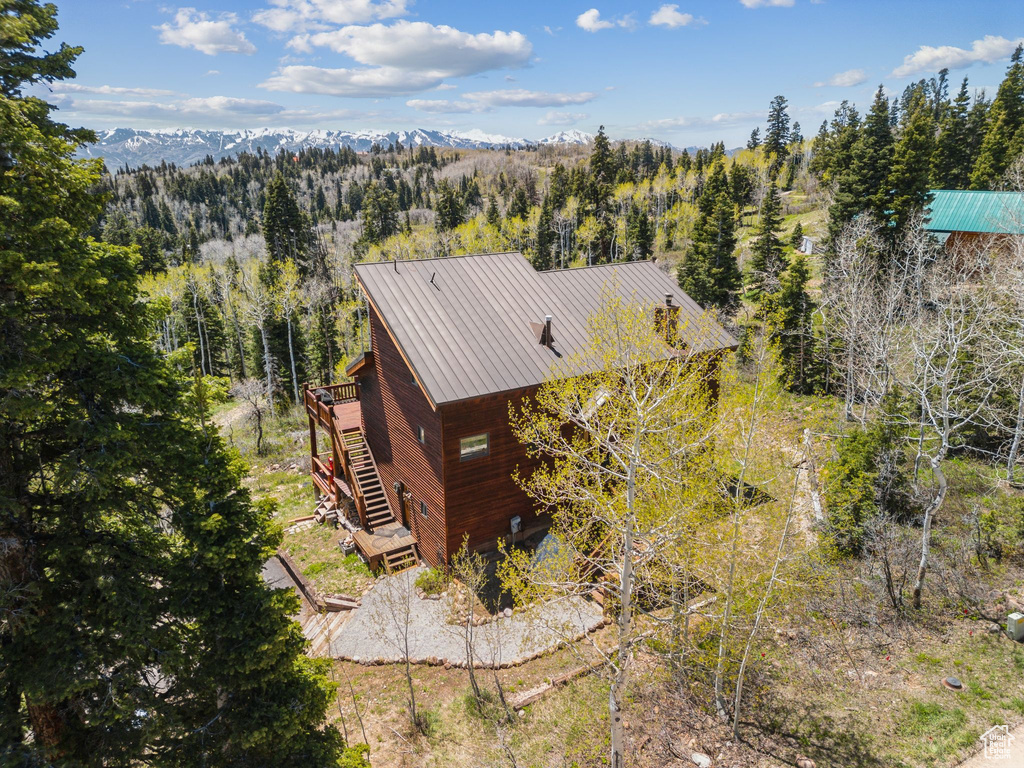 Aerial view of property and surrounding area with a heavily wooded area