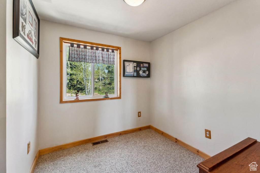 Carpeted empty room featuring baseboards