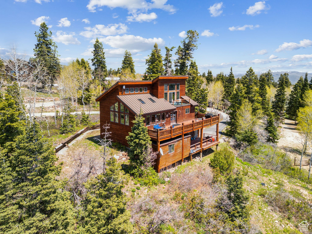 Rear view of house with a standing seam roof, metal roof, and a wooden deck