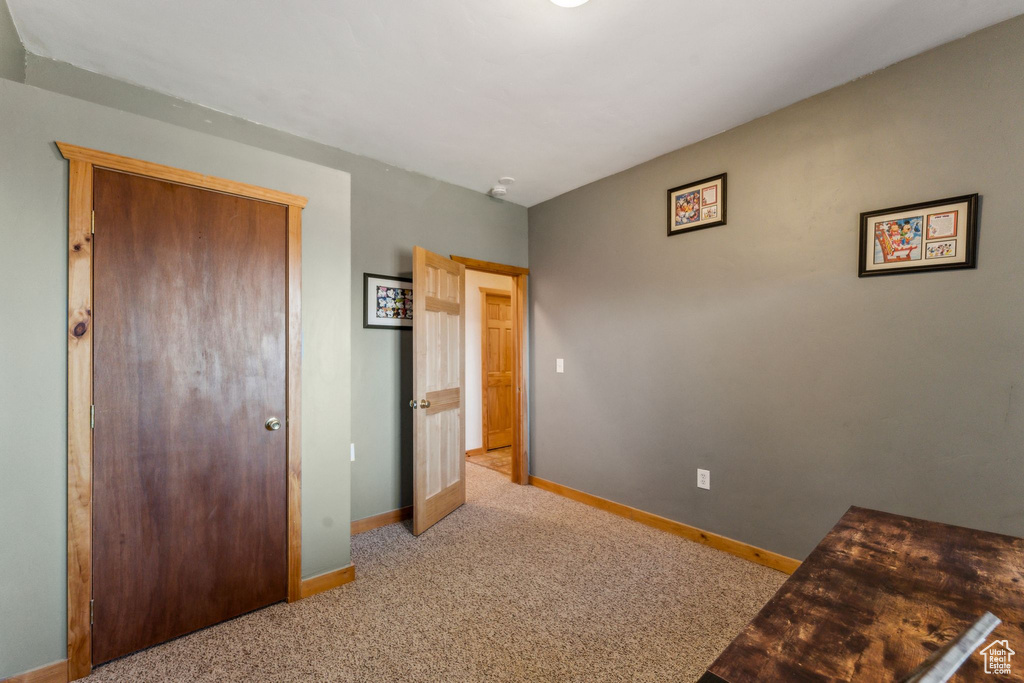 Unfurnished bedroom with baseboards, carpet, and a closet