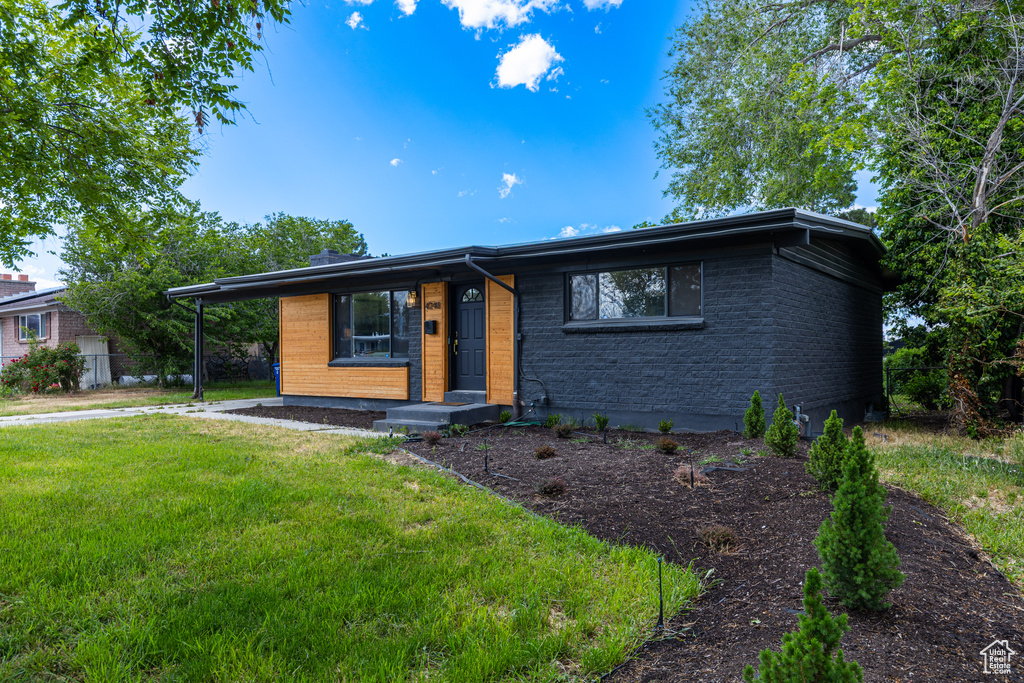 View of front of home featuring a front yard and brick siding