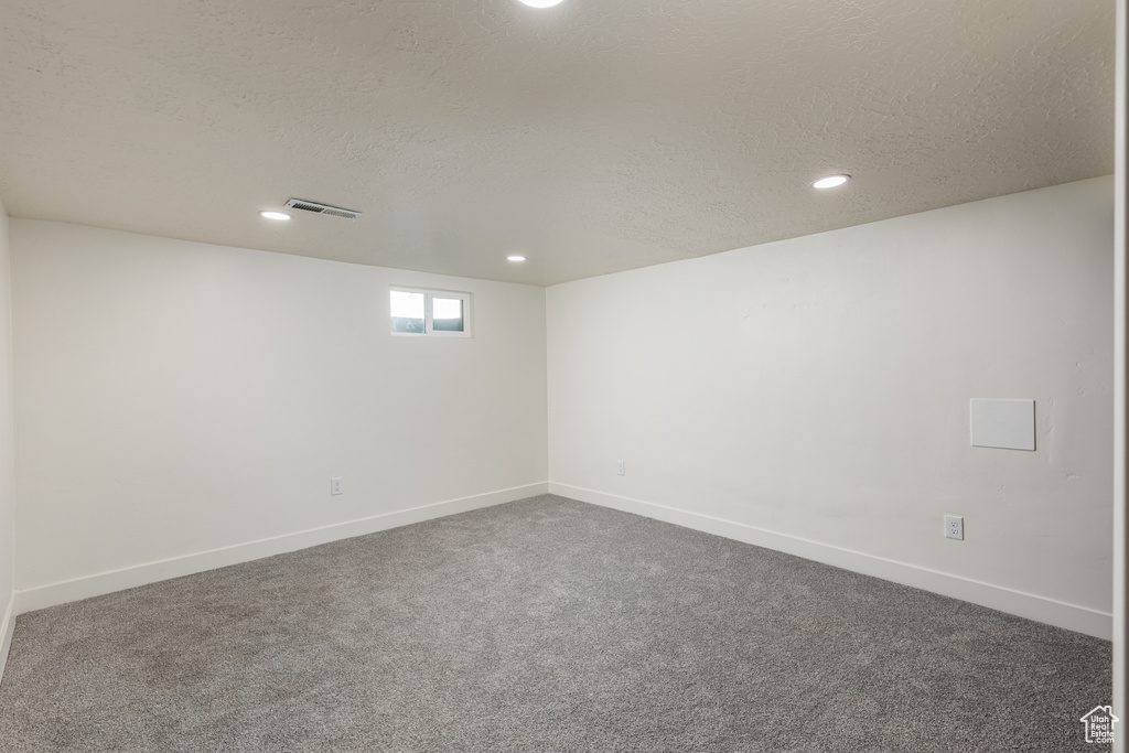 Unfurnished room with recessed lighting, dark colored carpet, a textured ceiling, and baseboards