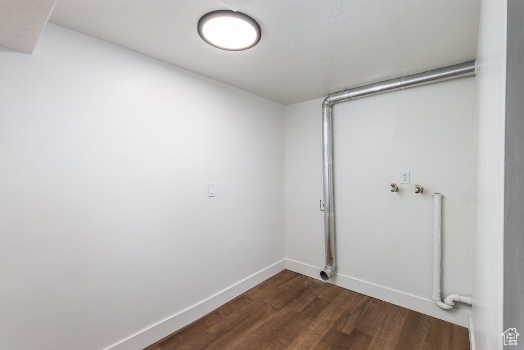 Laundry room featuring dark wood finished floors, baseboards, and hookup for a washing machine