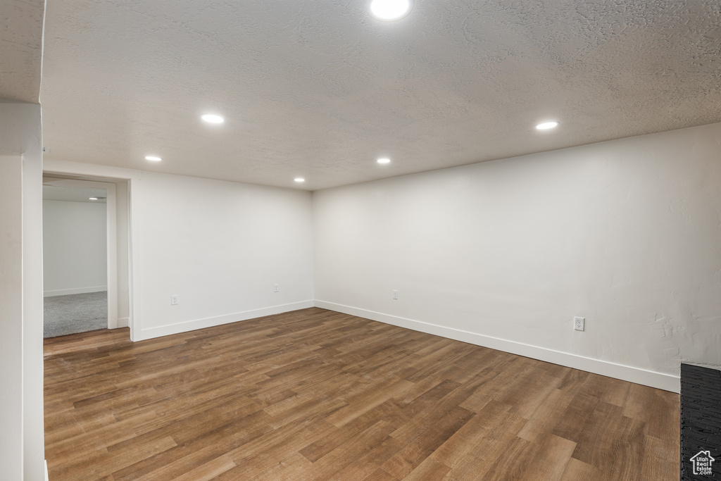 Basement with wood finished floors, recessed lighting, baseboards, and a textured ceiling