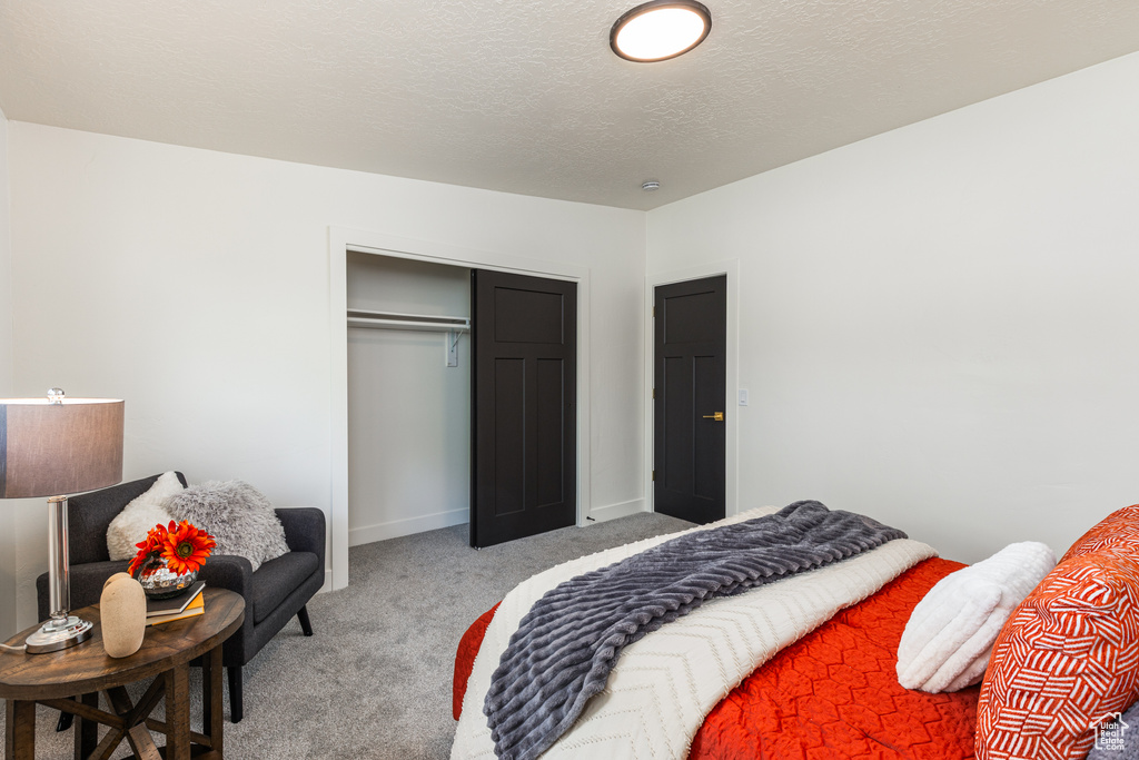 Bedroom featuring light colored carpet, a closet, and baseboards