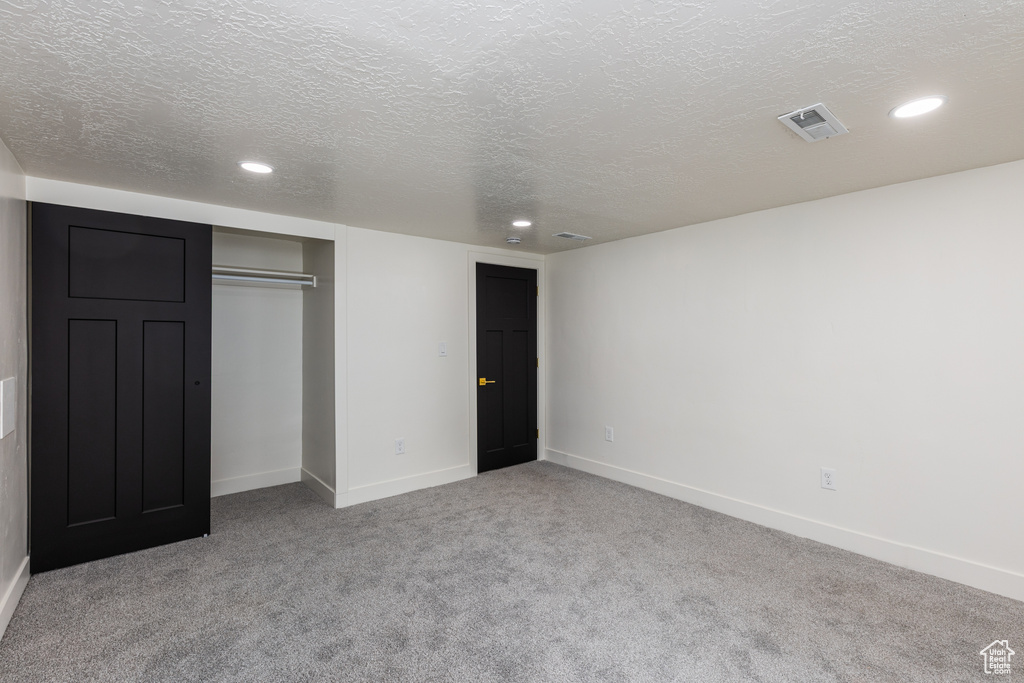 Unfurnished bedroom featuring carpet floors, a closet, recessed lighting, baseboards, and a textured ceiling