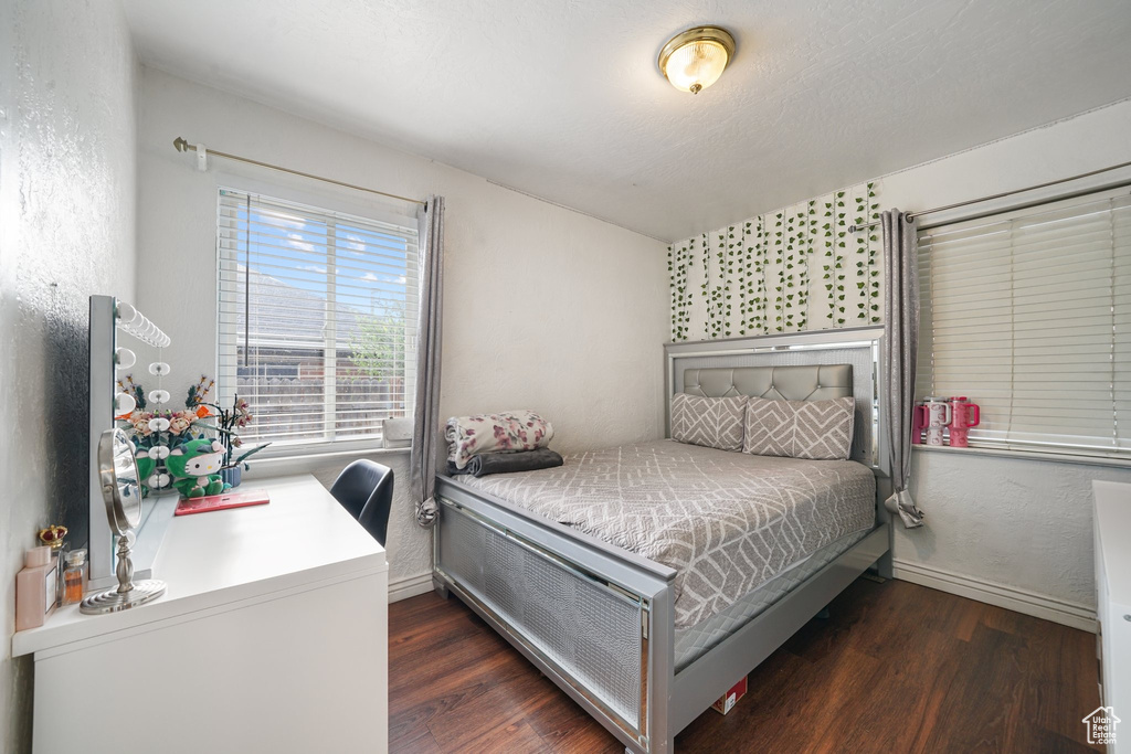 Bedroom with wood finished floors and baseboards
