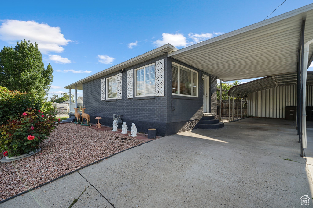 View of home's exterior with entry steps, concrete driveway, and brick siding