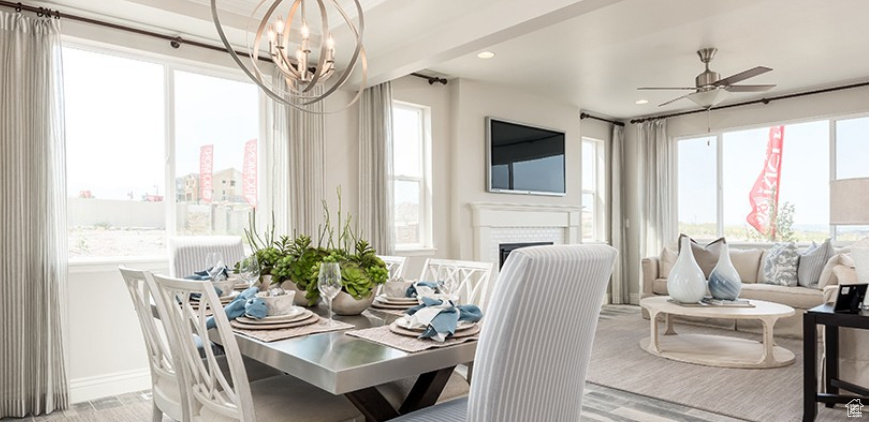 Dining room with a chandelier, ceiling fan, a fireplace, wood finished floors, and recessed lighting