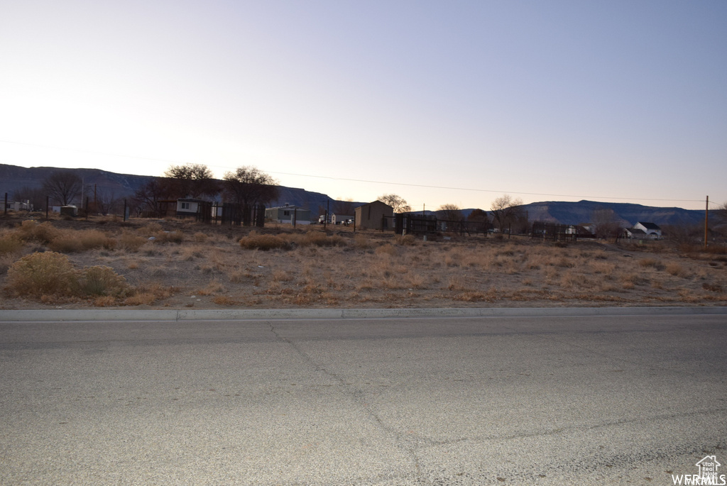 View of asphalt road with a mountain view and curbs