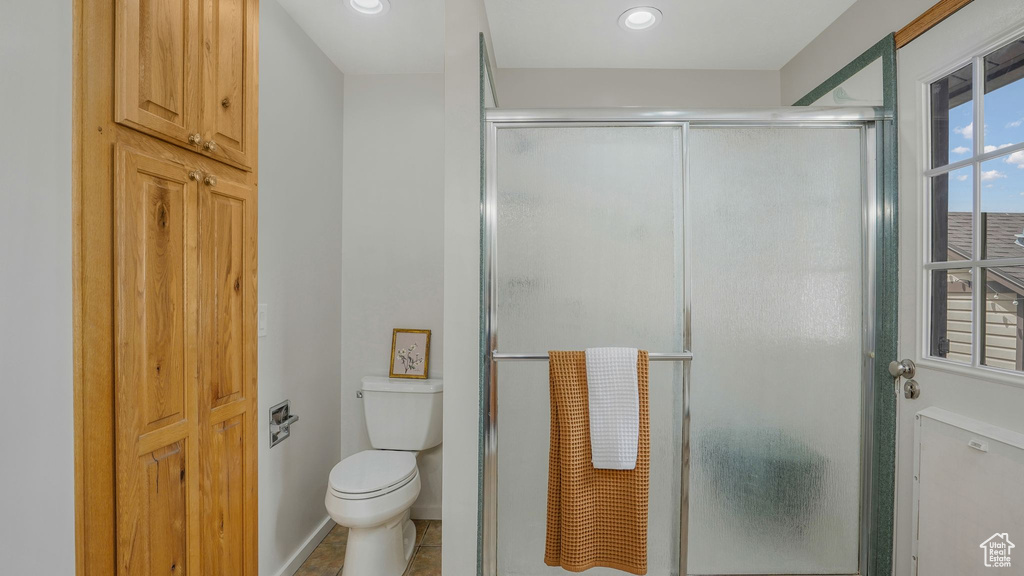 Full bath with toilet and a shower stall