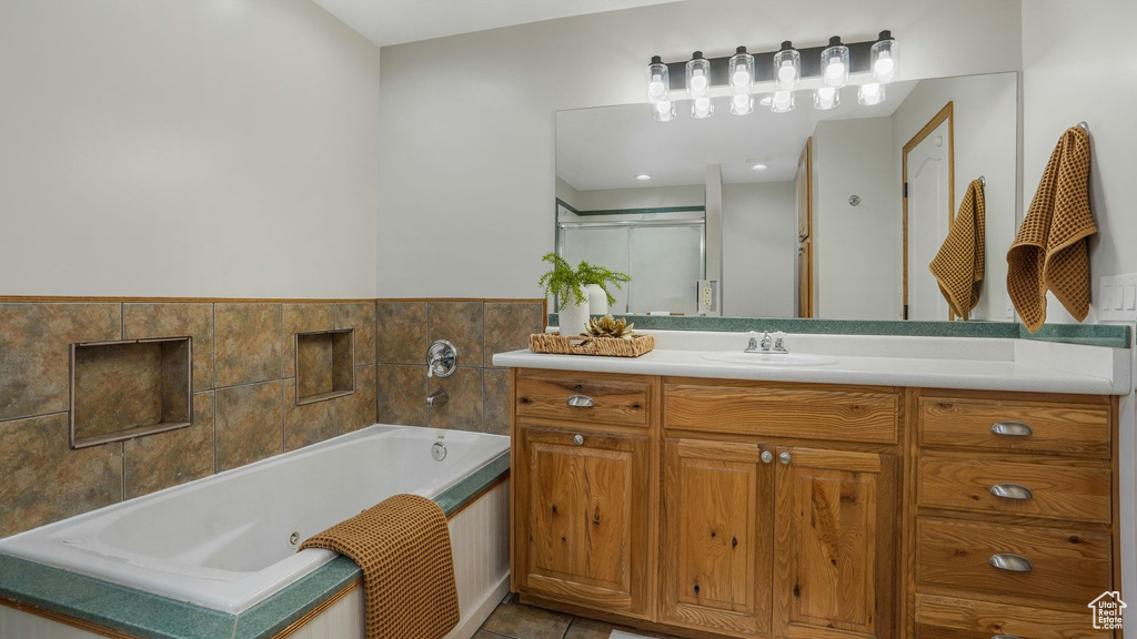Full bath featuring vanity, a whirlpool tub, tile patterned floors, and a shower with door