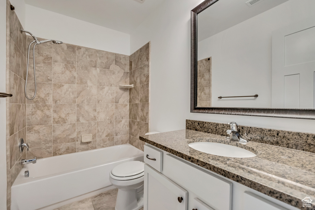 Full bath featuring vanity, toilet,  shower combination, and tile patterned floors