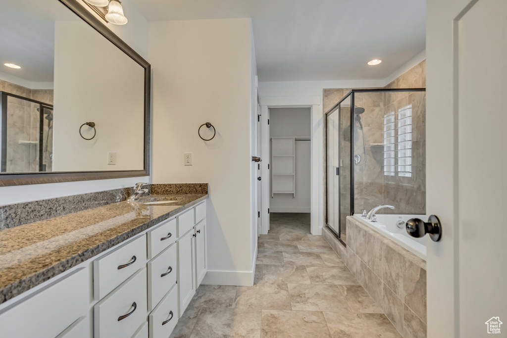 Bathroom with a shower stall, vanity, a garden tub, baseboards, and recessed lighting
