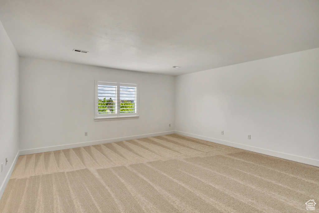 Spare room featuring baseboards and light colored carpet