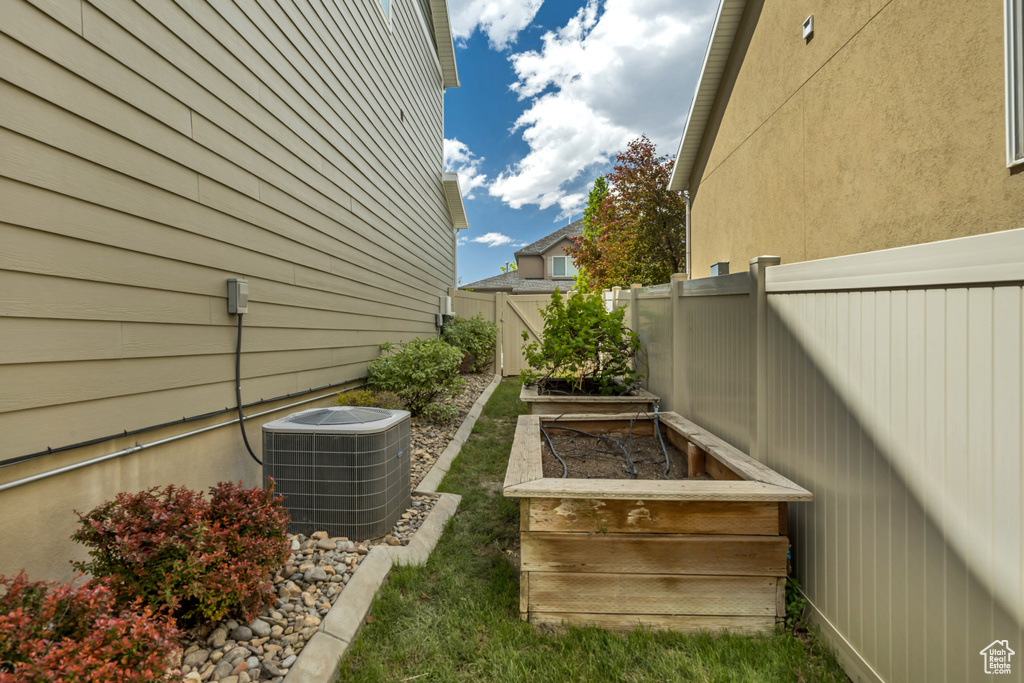 View of yard with central AC unit and a garden