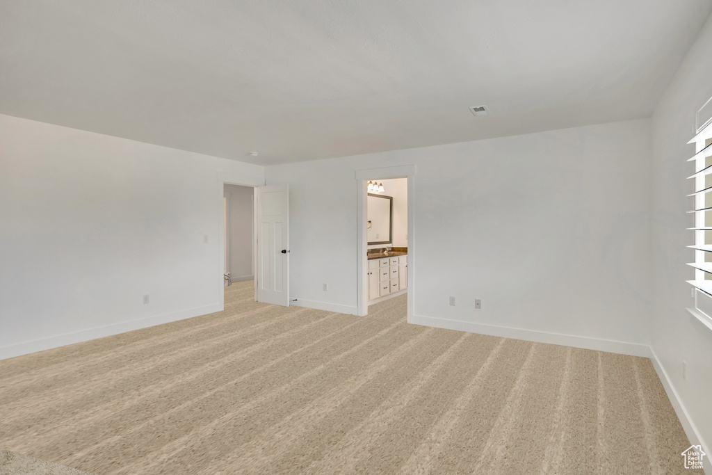 Spare room with baseboards and light colored carpet