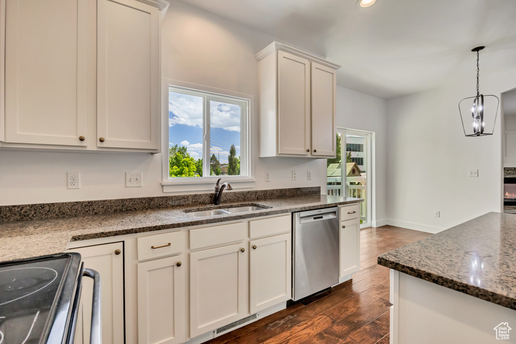 Kitchen featuring dishwasher, a sink, decorative light fixtures, black electric range, and dark wood-style flooring