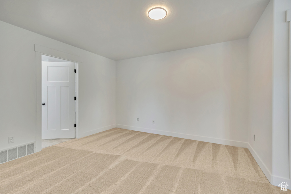 Empty room with light carpet and baseboards