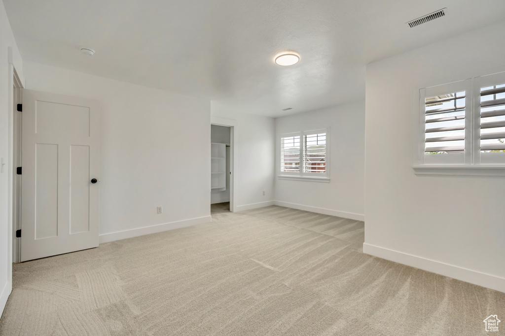 Carpeted empty room featuring baseboards and a smoke detector