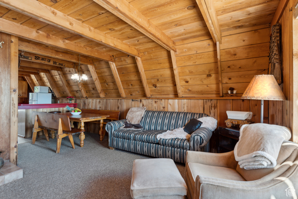 Living room featuring wooden ceiling, carpet floors, wooden walls, and a chandelier