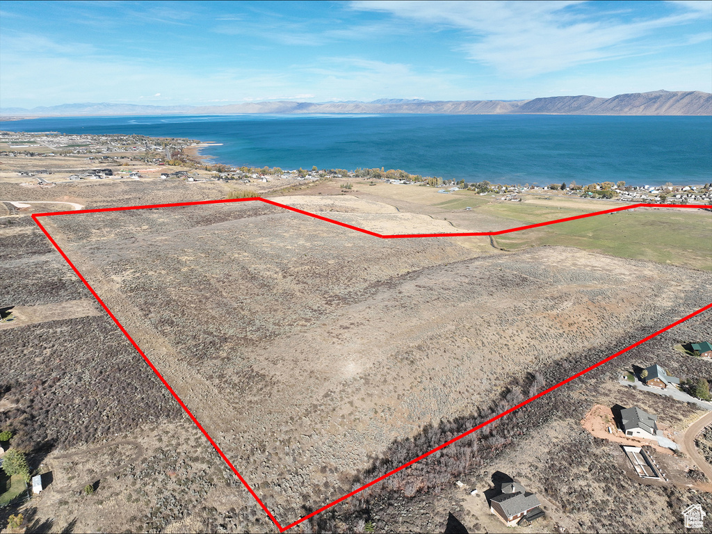 Aerial overview of property's location with property parcel outlined and a water and mountain view