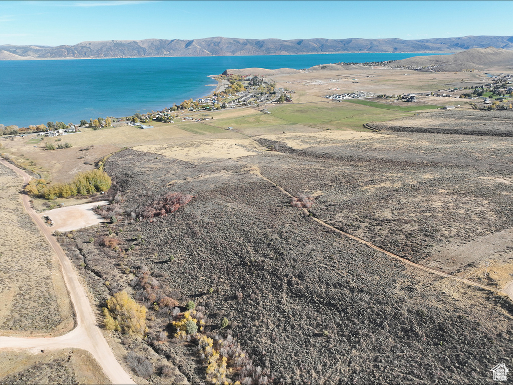 Aerial view of property and surrounding area with a water and mountain view