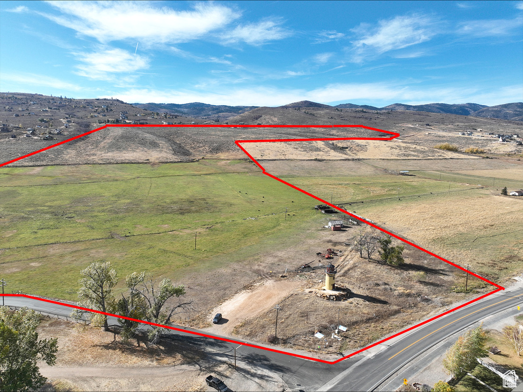 Aerial view of sparsely populated area with a mountain backdrop and property parcel outlined