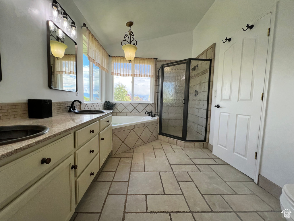 Bathroom with a garden tub, a stall shower, and double vanity