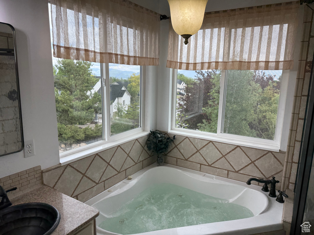 Bathroom with a bath, plenty of natural light, and vanity