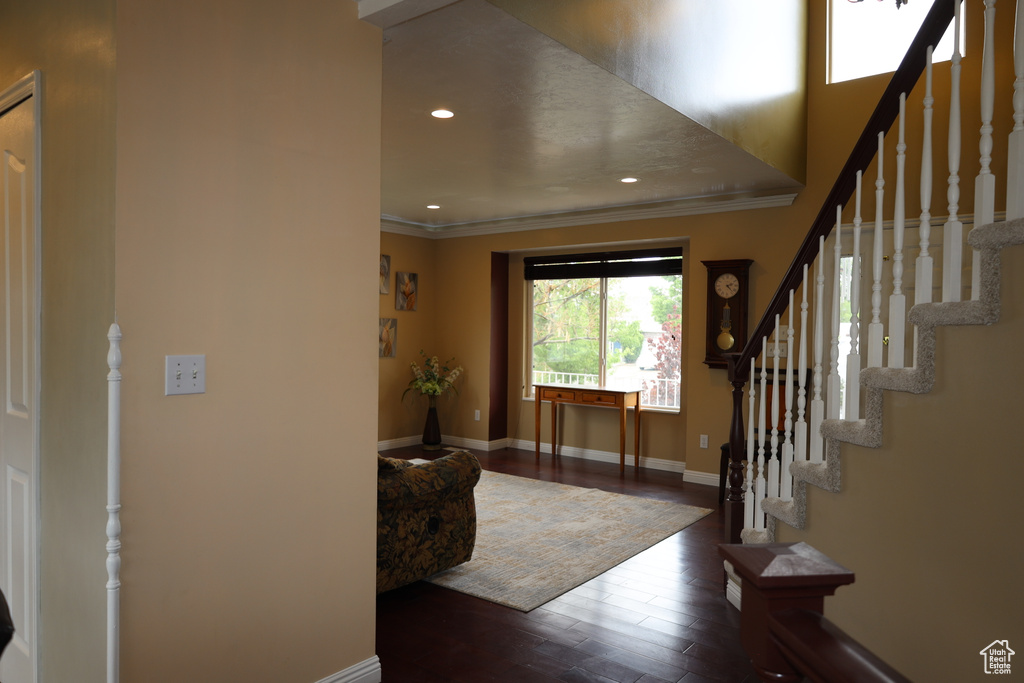 Foyer entrance featuring crown molding, wood finished floors, stairs, baseboards, and recessed lighting