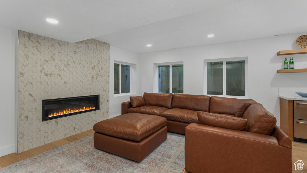 Living area with wood finished floors, a fireplace, and recessed lighting